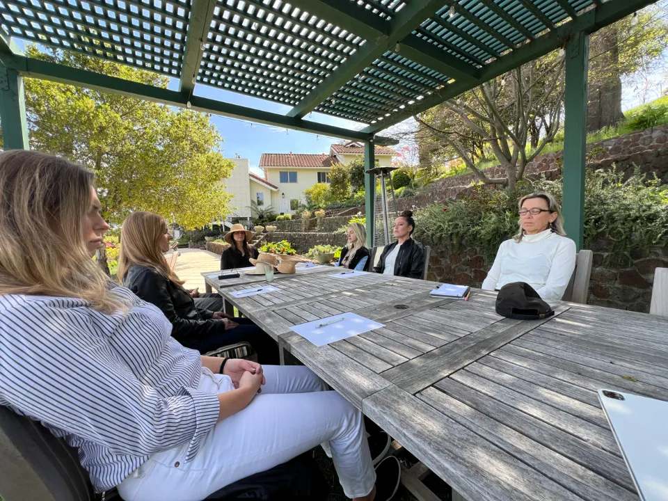 Women in a guided mindfulness session at an outdoor retreat
